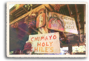 A stand in Chimayó sells Chimayo chile ristras, fruit and retablos. A sign proclaims the chiles are holy.