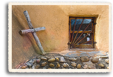 In Chimayó, New Mexico, a handmade cross sits in the corner of a traditional adobe style mission chapel, the Santuario de Chimayo. inside the window is the Sacristy, where pilgrims to the santuario leave rosaries, crutches, gifts and photos as evidence of healing.